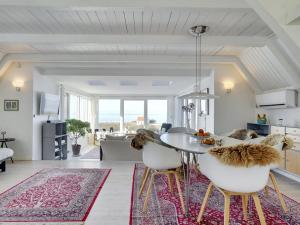 a kitchen and living room with a table and chairs at Holiday Home Aranja - 300m to the inlet by Interhome in Løgstør +30 photos