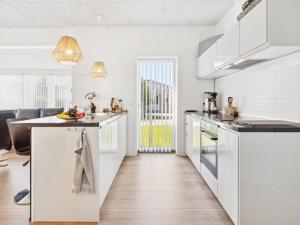 eine Küche mit weißen Schränken und einer Arbeitsplatte in der Unterkunft Holiday Home Thorlaf - 200m from the sea in SE Jutland by Interhome in Hejls