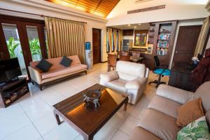 a living room with couches and a coffee table at Amazing Beachfront Villa in Ko Lanta