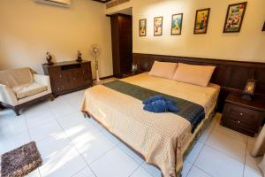 a bedroom with a large bed and a chair at Amazing Beachfront Villa in Ko Lanta
