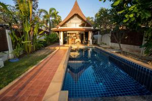 a swimming pool in front of a house at Amazing Beachfront Villa in Ko Lanta