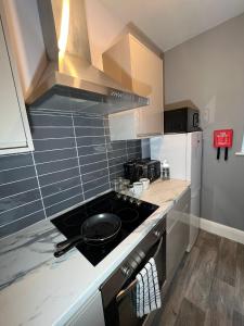 a kitchen with a stove top oven next to a refrigerator at Apt 3. Private Studio in Moseley, Birmingham in Birmingham