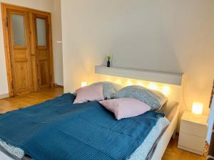 a bedroom with a bed with blue sheets and pink pillows at Apartment Villa am Großen Garten by Interhome in Dresden