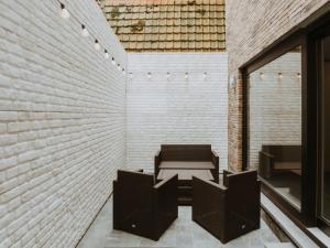 ein Zimmer mit einem Tisch, Stühlen und einer Ziegelwand in der Unterkunft Studio Studio Oasi with parking by Interhome in Blankenberge