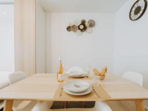 ein weißes Esszimmer mit einem Holztisch und Stühlen in der Unterkunft Studio Studio Oasi with parking by Interhome in Blankenberge