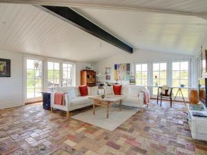 a living room with two couches and a table at Holiday Home Ovelil - 650m from the sea in Western Jutland by Interhome in Vejers Strand