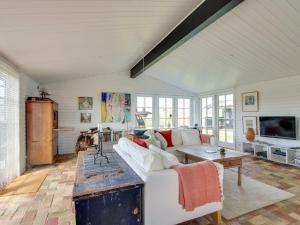 a living room with a white couch and a table at Holiday Home Ovelil - 650m from the sea in Western Jutland by Interhome in Vejers Strand