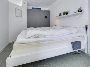 - un lit blanc dans une chambre aux murs blancs dans l'établissement Apartment Jaakko - 100m from the sea in Western Jutland by Interhome, à Fanø