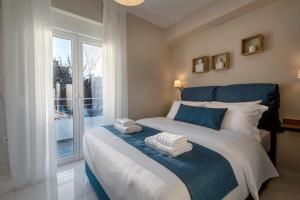 1 dormitorio con 1 cama grande y toallas. en CHE BELLO LUXURY APARTMENTS en Preveza