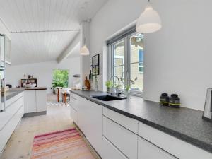 uma cozinha com armários brancos e um lavatório em Holiday Home Aswin in SE Jutland by Interhome em Silkeborg