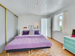 Un dormitorio con una gran cama púrpura y una ventana en Holiday Home Aswin in SE Jutland by Interhome, en Silkeborg