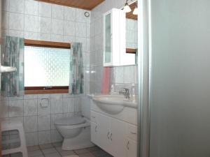 a bathroom with a sink and a toilet and a window at Holiday Home Nilda - 1km from the sea in Western Jutland by Interhome in Vejers Strand