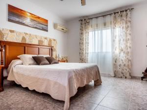ein Schlafzimmer mit einem großen Bett und einem Fenster in der Unterkunft Holiday Home San Fernando by Interhome in Villanueva del Río y Minas