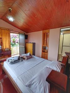 1 dormitorio con 1 cama grande y techo de madera en Parque Bioflora, en Dosquebradas