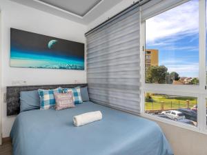 um quarto com uma cama azul e uma grande janela em Apartment La Torre by Interhome em Torremolinos