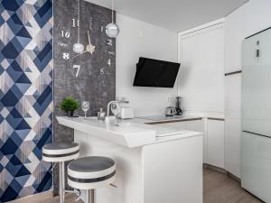 uma cozinha com um balcão branco e bancos em Apartment La Torre by Interhome em Torremolinos