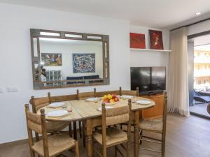 uma sala de jantar com uma mesa com cadeiras e um espelho em Apartment Galan by Interhome em Sant Antoni de Calonge