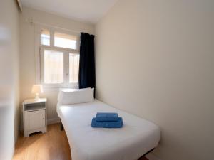 ein kleines Schlafzimmer mit einem weißen Bett und einem Fenster in der Unterkunft Apartment Sagrada Familia- Rossello by Interhome in Barcelona