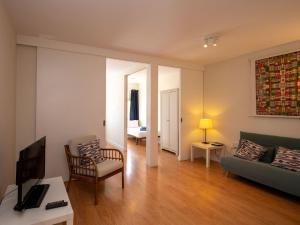 ein Wohnzimmer mit einem Sofa und einem TV in der Unterkunft Apartment Sagrada Familia- Rossello by Interhome in Barcelona