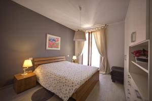 a bedroom with a bed and a large window at Holidays alle rose in Peschiera del Garda