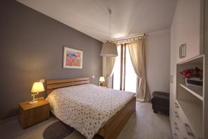 Un dormitorio con una cama y una ventana grande. en Holidays alle rose, en Peschiera del Garda
