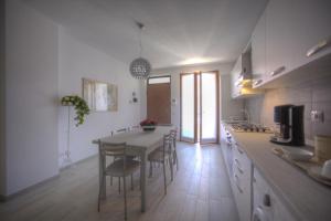 a kitchen with a table and chairs in a room at Holidays alle rose in Peschiera del Garda