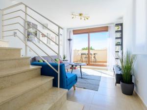 uma sala de estar com escadas e um sofá azul em Apartment Costa Golf Resort by Interhome em Sant Jordi