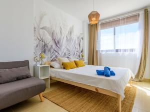 ein Schlafzimmer mit einem großen Bett und einem Sofa in der Unterkunft Apartment Costa Golf Resort by Interhome in Sant Jordi