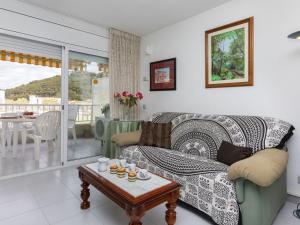 ein Wohnzimmer mit einem Sofa und einem Tisch in der Unterkunft Apartment Illa Mar d'Or by Interhome in L'Estartit