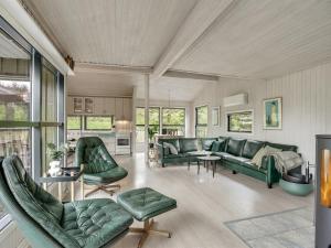 ein Wohnzimmer mit grünen Sofas und Stühlen in der Unterkunft Holiday Home Glenda - 3km from the sea in NW Jutland by Interhome in Saltum