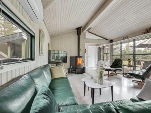 ein Wohnzimmer mit einem grünen Sofa und einem Tisch in der Unterkunft Holiday Home Glenda - 3km from the sea in NW Jutland by Interhome in Saltum