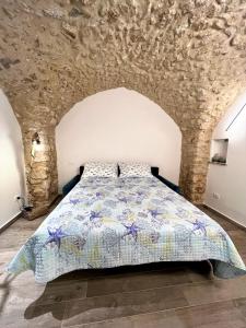 a bedroom with a bed in a stone wall at Divina Casa Vacanze Donna Filomena in Sperlonga