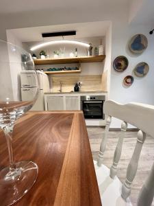 uma cozinha com uma mesa de madeira e um copo de vinho em Divina Casa Vacanze Donna Filomena em Sperlonga