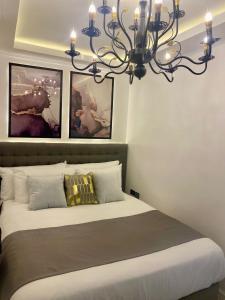 a bedroom with a large bed with a chandelier at MAKATI Isabela Luxury in Manila