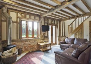 a living room with a couch and a fireplace at Red House Barns Sternfield in Friston