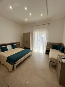 1 dormitorio grande con 2 camas y ventana en B&B MarAlè, en Porto Cesareo