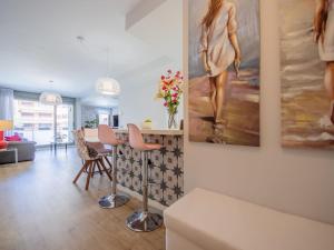 a living room with a table and paintings on the wall at Apartment Barcelona by Interhome in Torredembarra