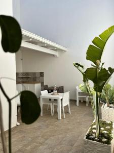 Una sala de estar con mesa, sillas y plantas. en B&B MarAlè, en Porto Cesareo