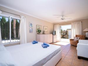 a bedroom with a white bed and a living room at Villa Marita by Interhome in Moraira