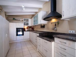 a kitchen with white cabinets and a stove top oven at Villa Marita by Interhome in Moraira +27 photos