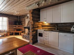 - une cuisine avec des placards blancs et un mur en bois dans l'établissement Holiday Home Kuukkelinkolo by Interhome, à Levi