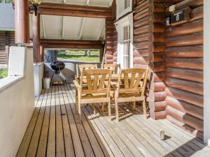 eine Holzterrasse mit einem Tisch und Stühlen darauf in der Unterkunft Holiday Home Honkakoli 8 by Interhome in Hattusaari