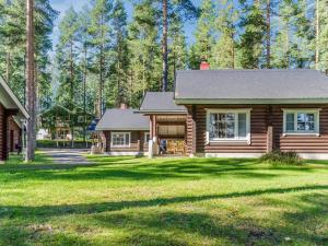 ein Blockhaus mit einem Hof und einem Haus in der Unterkunft Holiday Home Honkakoli 8 by Interhome in Hattusaari