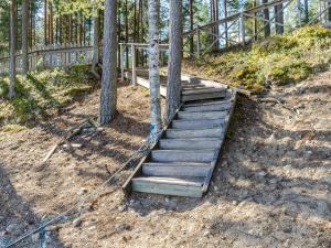 eine Holztreppe, die auf einen Hügel mit Bäumen führt in der Unterkunft Holiday Home Honkakoli 8 by Interhome in Hattusaari