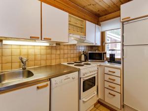 a kitchen with white cabinets and a sink at Holiday Home Honkakoli 6 by Interhome in Hattusaari