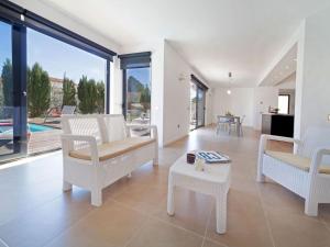 sala de estar con sillas blancas y mesa en Villa Villa Luxor by Interhome, en L'Ametlla de Mar