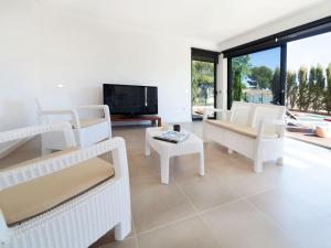 sala de estar con muebles blancos y TV en Villa Villa Luxor by Interhome, en L'Ametlla de Mar
