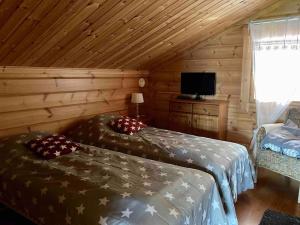 a bedroom with two beds in a log cabin at Villa Maaria, LaatuLomat in Juva