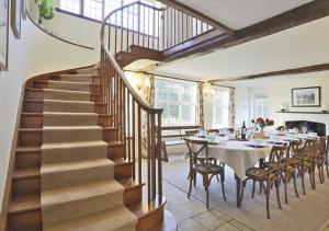 eine Treppe in einem Esszimmer mit einem Tisch und Stühlen in der Unterkunft Park Farm House in Wangford