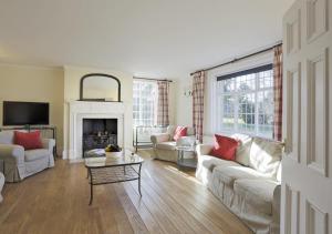 a living room with white furniture and a fireplace at Park Farm House in Wangford